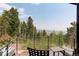 Balcony with seating overlooks a lush forest, offering a serene outdoor space at 116 Ramona Rd, Golden, CO 80403