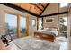 Sun-filled bedroom features a vaulted wood ceiling, a ceiling fan, and doors to an outdoor deck at 116 Ramona Rd, Golden, CO 80403