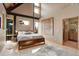 Bedroom with vaulted ceiling features hardwood floors and scenic forest views from many windows at 116 Ramona Rd, Golden, CO 80403