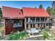 Stunning modern home with a red roof, stone and metal siding, balconies, and a hot tub with mature landscaping at 116 Ramona Rd, Golden, CO 80403