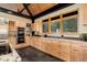 Modern kitchen with stainless steel appliances, light wood cabinetry, granite countertops, and black tile floor at 116 Ramona Rd, Golden, CO 80403
