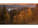 Panoramic view of a serene lake surrounded by lush autumn colored trees at 116 Ramona Rd, Golden, CO 80403