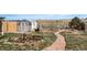 Wide shot of the backyard with a small shed, stone path, decorative art, and open space at 34280 Columbine E Trl, Elizabeth, CO 80107