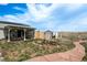 Expansive backyard featuring a covered patio, shed, and decorative rock pathway with a manicured lawn at 34280 Columbine E Trl, Elizabeth, CO 80107