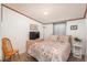 Well-lit bedroom featuring a floral bedspread, wood furniture, and calming decor at 34280 Columbine E Trl, Elizabeth, CO 80107