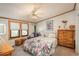 Bright bedroom featuring a floral-patterned bed, wood trim, and a sunny window at 34280 Columbine E Trl, Elizabeth, CO 80107