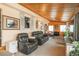 Cozy living room with wood paneling, beamed ceilings and comfortable seating at 34280 Columbine E Trl, Elizabeth, CO 80107