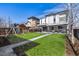 Well-manicured backyard offers a pristine lawn, playset and landscaped surroundings on a sunny day at 2224 W 37Th Ave, Denver, CO 80211