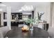 View from the dining room, showing a round table, modern lighting, and into the kitchen with island and bar stools at 2224 W 37Th Ave, Denver, CO 80211