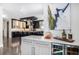 View of a modern kitchen with dark cabinetry, stainless steel appliances, a large island, and a beverage refrigerator at 2224 W 37Th Ave, Denver, CO 80211