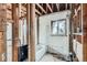 Unfinished bathroom with exposed wooden studs and a tub at 1645 Tamarac St, Denver, CO 80220