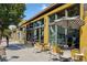 Sunny street view of a business district featuring outdoor seating and large windows and a striped umbrella at 4312 Xavier St, Denver, CO 80212