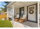 Inviting front porch featuring rocking chairs, a small table, and a decorative wreath, offering a cozy outdoor space at 4312 Xavier St, Denver, CO 80212