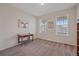 Cozy bedroom with plush carpeting, a decorative table, and two windows overlooking the neighborhood at 1202 Lance Leaf Ct, Elizabeth, CO 80107