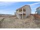 Rear exterior view showcasing the home's architecture, a covered deck, and a spacious backyard at 1202 Lance Leaf Ct, Elizabeth, CO 80107