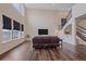 Spacious living room with hardwood floors, large windows, and a modern staircase at 1202 Lance Leaf Ct, Elizabeth, CO 80107