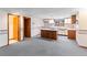 Basement kitchenette with a center island, neutral colored cabinets, and patterned wallpaper at 11686 W 74Th Way, Arvada, CO 80005