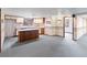 Basement kitchenette featuring a center island, neutral colored cabinets and access to another room at 11686 W 74Th Way, Arvada, CO 80005