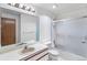 Bathroom featuring a shower, sink, and an illuminated mirror, creating a relaxing atmosphere at 11686 W 74Th Way, Arvada, CO 80005