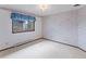 This bedroom features a large window, light fixture, baseboard heating, and patterned wallpaper at 11686 W 74Th Way, Arvada, CO 80005