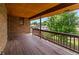 Wooden deck featuring surrounding trees and a connection to a brick exterior at 11686 W 74Th Way, Arvada, CO 80005