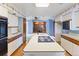 Bright kitchen boasts an island with cooktop, ample counter space, and lots of built in storage at 11686 W 74Th Way, Arvada, CO 80005