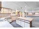 Basement kitchenette featuring an island, neutral colored cabinets and access to a large room at 11686 W 74Th Way, Arvada, CO 80005