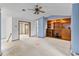 Living room with blue walls, carpet flooring, ceiling fan, and built-in shelves at 11686 W 74Th Way, Arvada, CO 80005