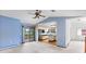 An open floor plan showcasing blue walls, the kitchen, ceiling fan, and access to a deck at 11686 W 74Th Way, Arvada, CO 80005