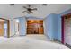 Spacious living room features carpet, built in shelves, blue walls, and ceiling fan at 11686 W 74Th Way, Arvada, CO 80005