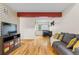 Living room view highlighting hardwood floors, a couch, and a tv stand at 6545 W 84Th Way # 132, Arvada, CO 80003