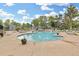 Community pool surrounded by lounge chairs, umbrellas, and well-kept landscaping at 6545 W 84Th Way # 132, Arvada, CO 80003