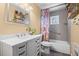 Well-lit bathroom featuring plants, vanity with white cabinet and tub with colorful shower curtain at 4311 Del Rio Ct, Denver, CO 80239