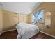 Simple bedroom features light walls, mirror, window and wood floors at 4311 Del Rio Ct, Denver, CO 80239