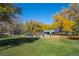 Community playground featuring colorful equipment, swings, and a covered picnic area, surrounded by lush greenery and autumn foliage at 4311 Del Rio Ct, Denver, CO 80239