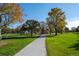 A picturesque concrete path winds through a green park with mature trees and open grassy areas, inviting leisurely strolls at 4311 Del Rio Ct, Denver, CO 80239