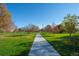 Scenic view of a paved walking path lined with trees and lush green grass, creating a peaceful and inviting outdoor space at 4311 Del Rio Ct, Denver, CO 80239