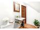 Bathroom featuring marble vanity, hardwood floors, dark wood door, and white walls at 3217 Irving St, Denver, CO 80211