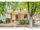 Charming home exterior featuring a stone-columned porch and lush landscaping at 3217 Irving St, Denver, CO 80211