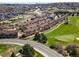 An aerial view displays multi-Gathering homes adjacent to a golf course and curving road in a suburban setting at 1344 Royal Troon Dr, Castle Rock, CO 80104