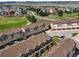 A beautiful aerial view shows a neighborhood of townhomes bordering a manicured golf course on a sunny day at 1344 Royal Troon Dr, Castle Rock, CO 80104