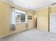 Bedroom with carpeted floor, window with blinds, yellow walls, and a white door at 1344 Royal Troon Dr, Castle Rock, CO 80104