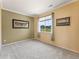 Bedroom with neutral walls, carpet, large window with blinds and curtains, and two framed pictures at 1344 Royal Troon Dr, Castle Rock, CO 80104