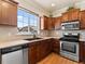 Well-lit kitchen features stainless steel appliances, wood cabinets, and a view to the neighborhood at 1344 Royal Troon Dr, Castle Rock, CO 80104