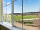 View of a golf course, green spaces and other homes from the window with mesh screen at 1344 Royal Troon Dr, Castle Rock, CO 80104