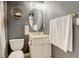 Cozy half-bathroom with grey walls, white vanity with marble countertops, and brushed gold fixtures at 9141 Roundtree Dr, Highlands Ranch, CO 80126