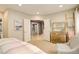 Bright bedroom features neutral walls, carpet, dresser, and ensuite, offering a warm and inviting space at 9141 Roundtree Dr, Highlands Ranch, CO 80126