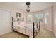 Bright bedroom featuring a wrought iron bed frame, plantation shutters, and neutral carpet at 9141 Roundtree Dr, Highlands Ranch, CO 80126