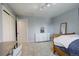Comfortable bedroom featuring neutral walls, a study desk and chair, plus a view into the connected bathroom at 9141 Roundtree Dr, Highlands Ranch, CO 80126
