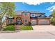 Two-story brick home featuring an arched entryway, manicured lawn, and attached two-car garage at 9141 Roundtree Dr, Highlands Ranch, CO 80126